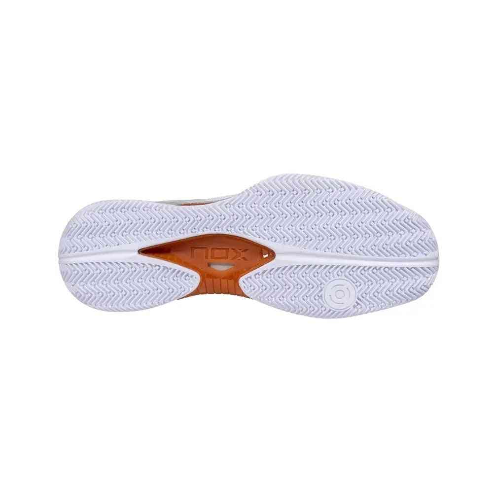 Outsole of Nox Lux Nerbo White Coral Caluxnerwhcor padel shoe showing herringbone tread for superior grip and stability on court surfaces.