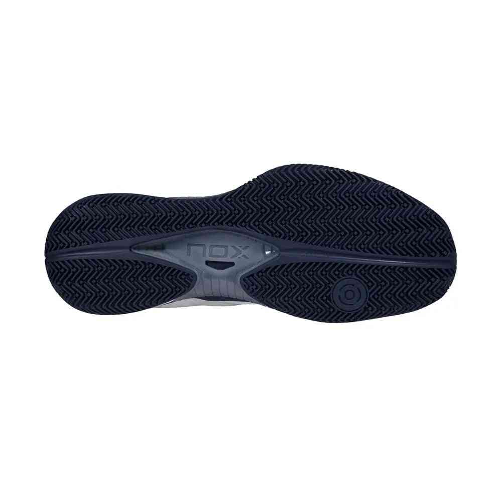 Outsole view of Nox Lux Nerbo White Navy Blue Caluxnerwhna showing herringbone tread for superior grip on padel courts.