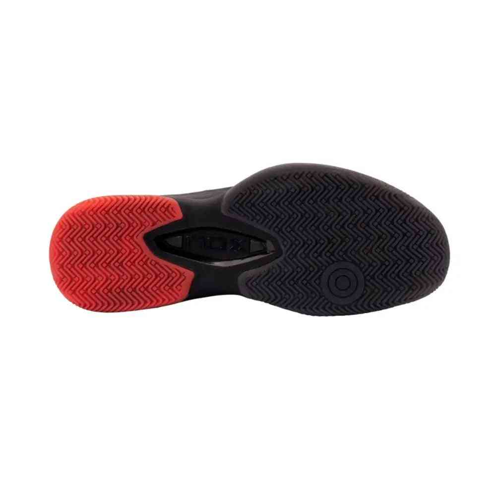 Outsole view of Nox AT10 Lux Black Black Red Calatluxnero padel shoe, featuring durable herringbone tread for superior traction on court surfaces.