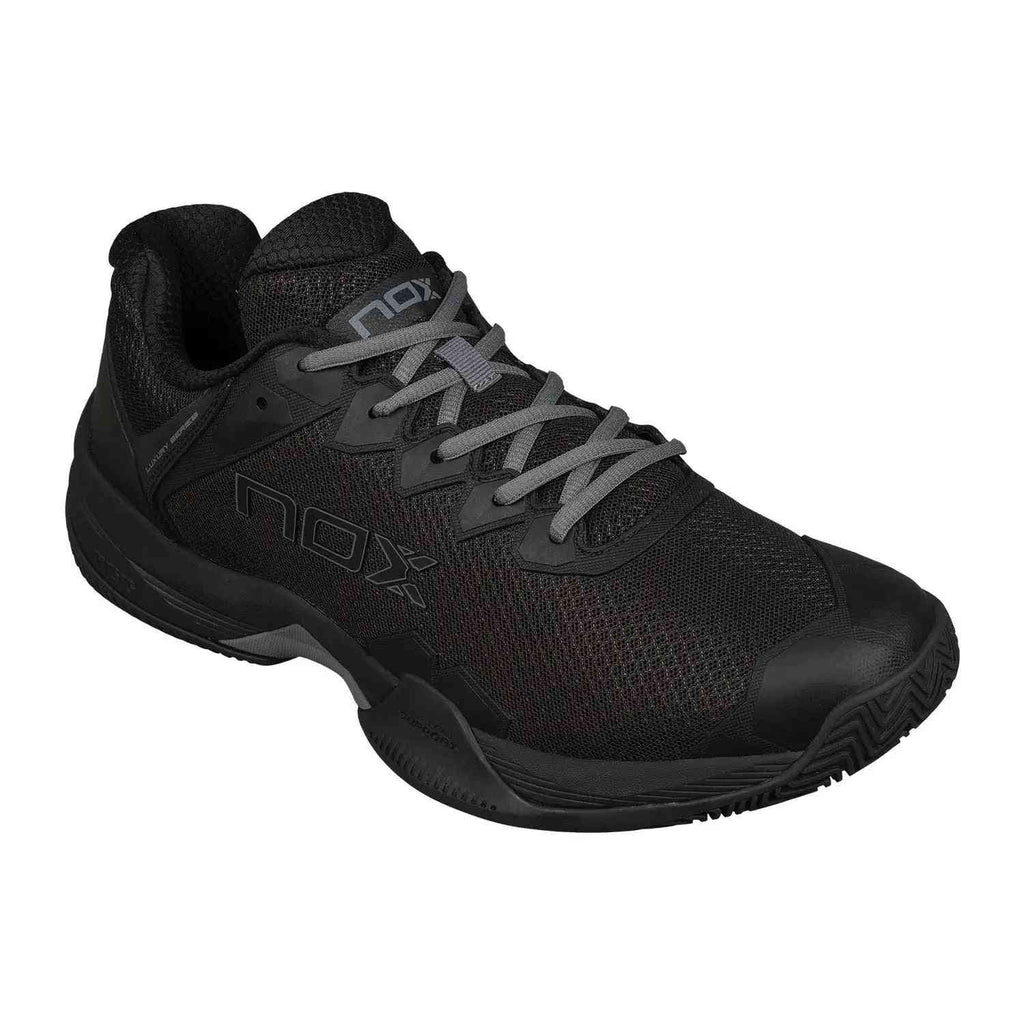 Angled view of Nox ML10 Hexa Calmlhexblgs Black padel shoe highlighting durable outsole and sleek all-black design for court stability.