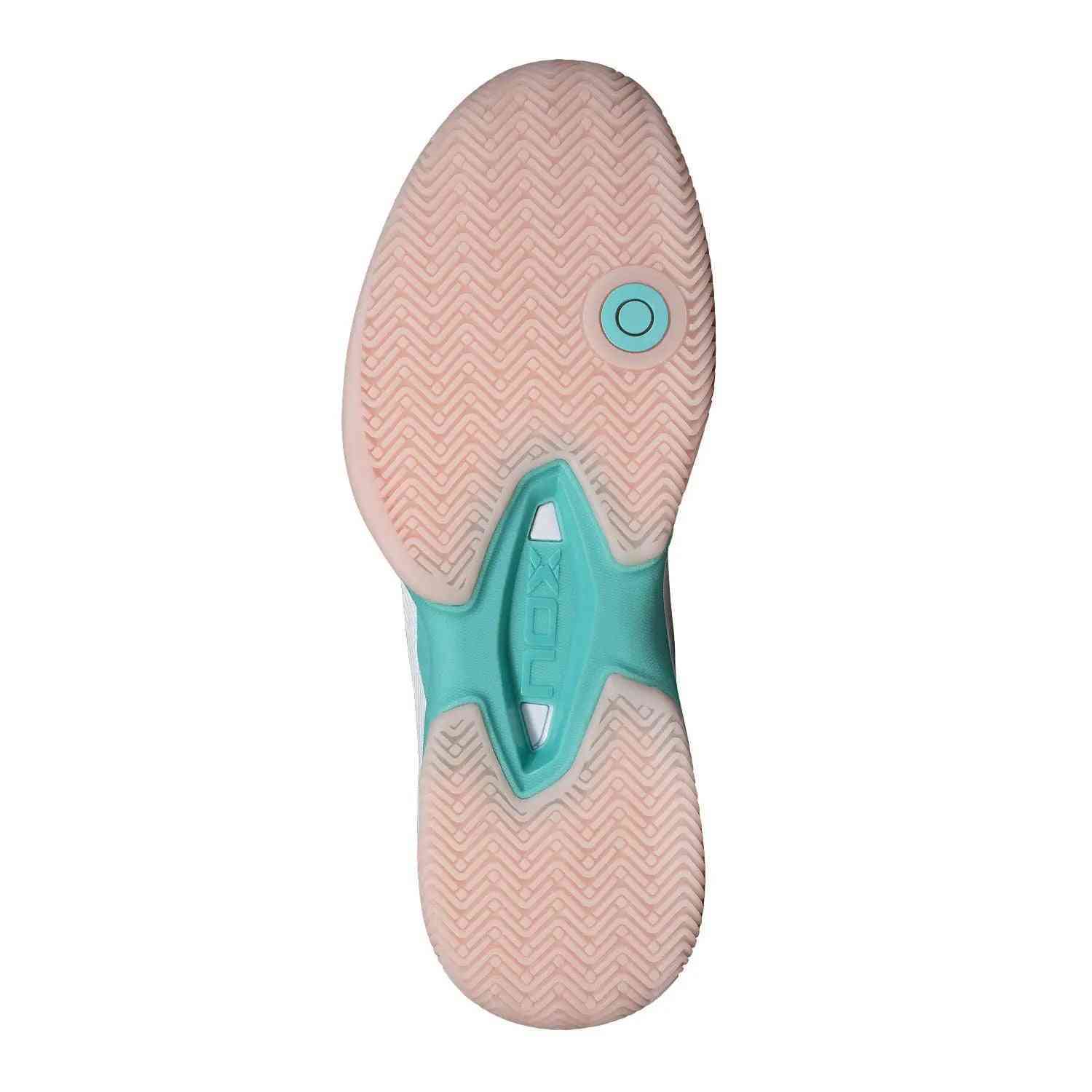 Outsole of Nox AT10 Lux Calatluxwhpo White Women's shoe featuring herringbone grip pattern and turquoise midfoot support for enhanced court traction.